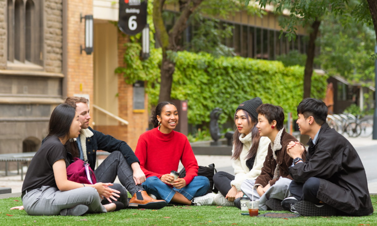 Finch students on city campus sitting and chatting in front of Building 1